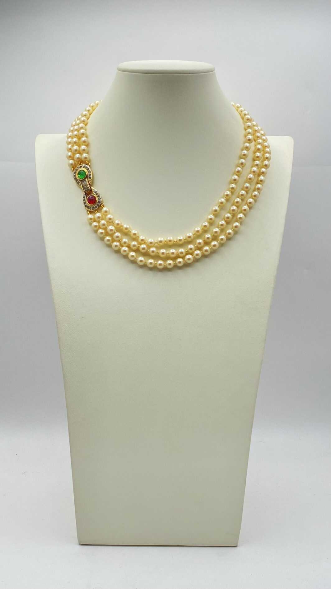 “VOGUE BIJOUX”. COLLANA A TRE FILI DI PERLE CON CHIUSURA IN METALLO GOLDTONE, PASTE DI VETRO COLORATE E CRISTALLI DIAMOND LIKE. BIGIOTTERIA AMERICANA ANNI ‘70