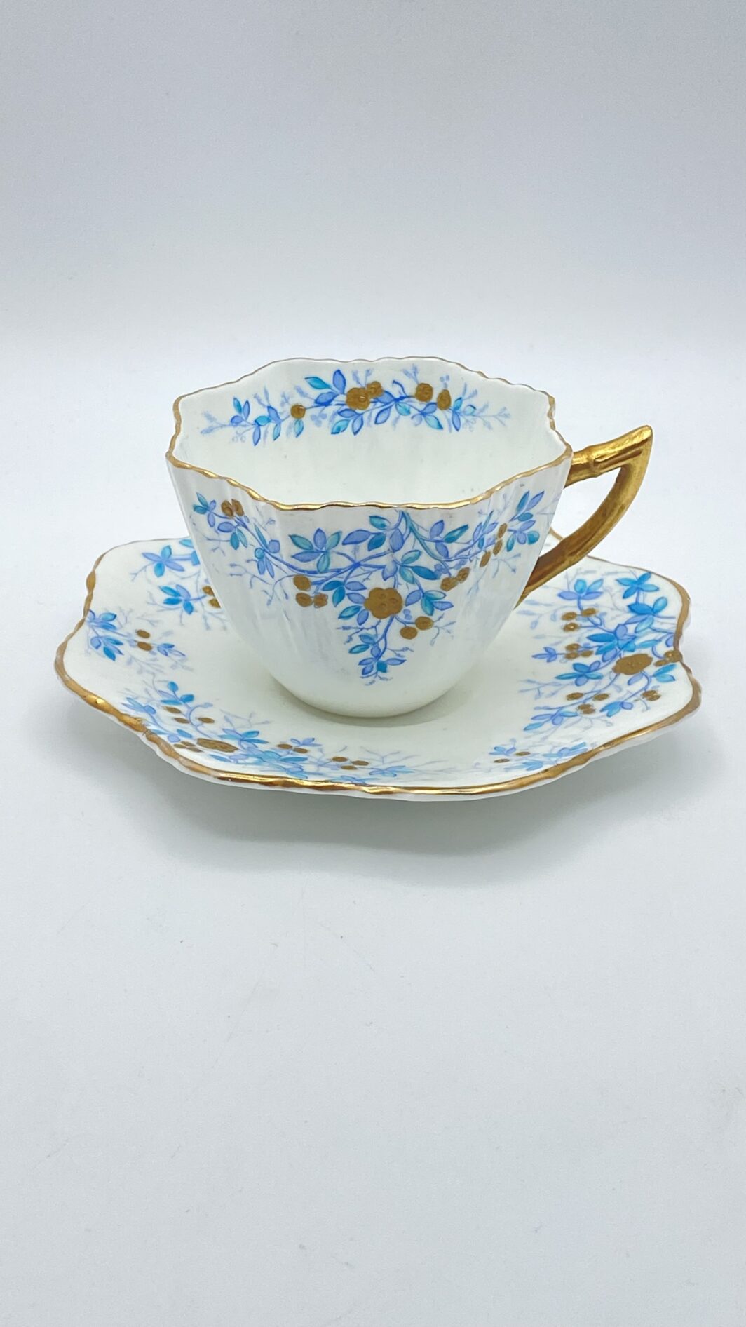 TAZZA DA TÉ VITTORIANA CON PIATTINO, IN PORCELLANA FINISSIMA, DI FORMA MOSSA. INGHILTERRA FINE XIX sec.