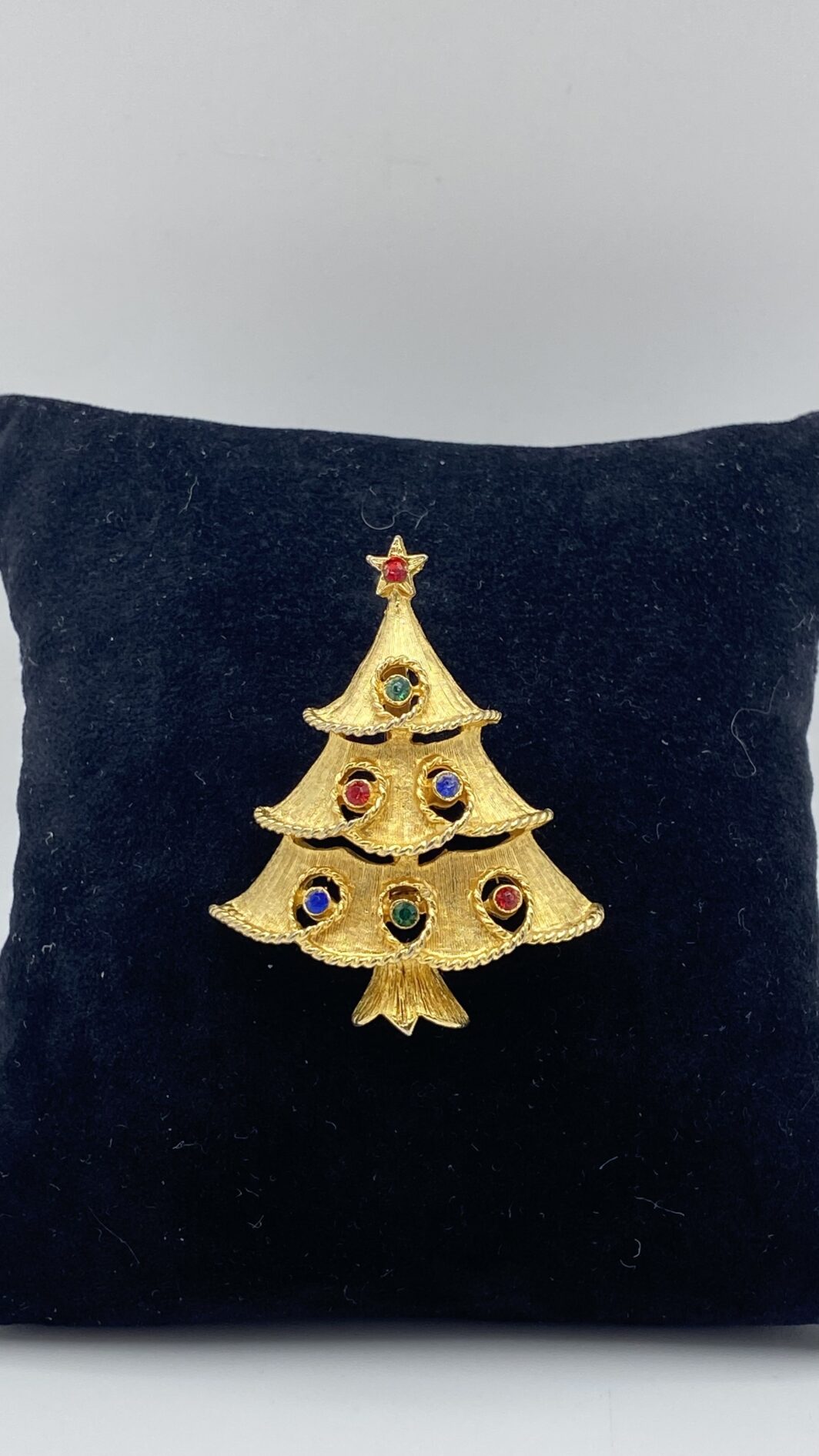 “J.J.” SPILLA VINAGE ANNI ‘50 A FORMA DI ALBERO DI NATALE, IN METALLO GOLDTONE E CRISTALLI POLICROMI. U.S.A.