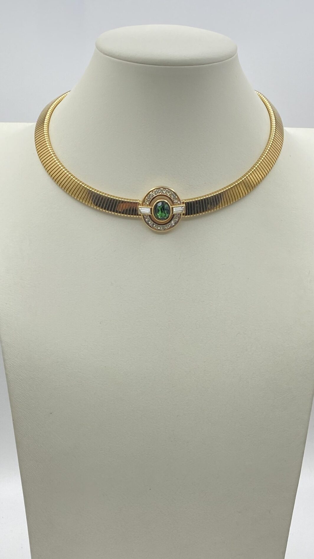 “D’ORLAN”. COLLIER TUBOGAS IN METALLO GOLDTONE, CON CENTRALE CON CRISTALLI DIAMOND-LIKE E VERDE SMERALDO. BIGIOTTERIA AMERICANA VINTAGE ANNI ‘60.